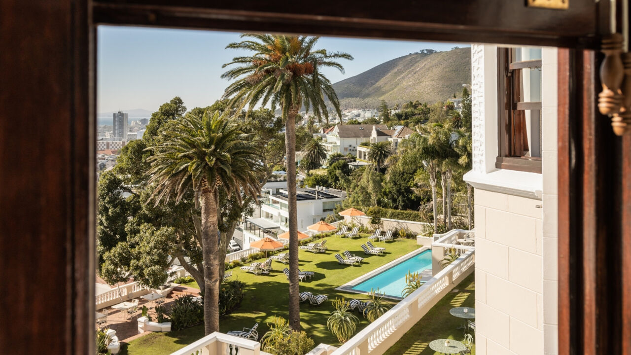 Blick aus dem Fenster auf den begrünten Poolbereich des Hotels