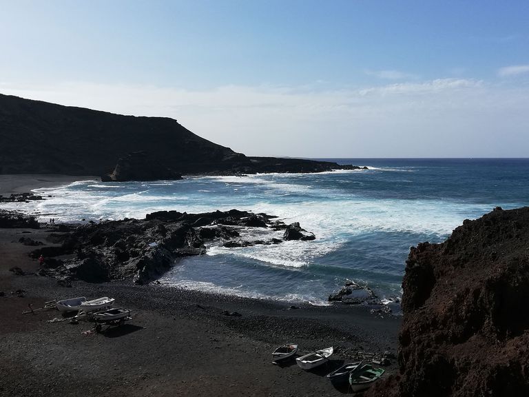 Schwarzer Vulkansand und zerklüftete Klippen: Das finden Reisende an der Küste von El Golfo. Lanzarote, Küste von El Golfo, Playa El Golfo