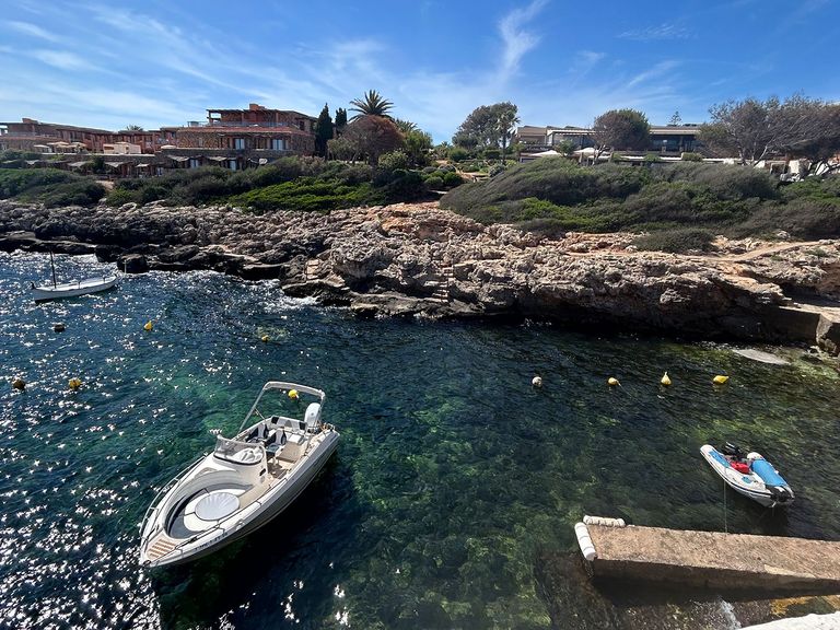 Direkt vor Binibeca erstreckt sich das Mittelmeer. Boot im Meer vor Binibeca, Menorca