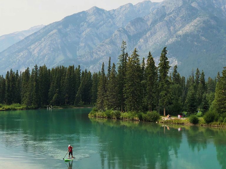 Der Banff Nationalpark birgt eine der schönsten Landschaften in ganz Kanada. Person auf einem SUP-Board im Banff Nationalpark in Kanada