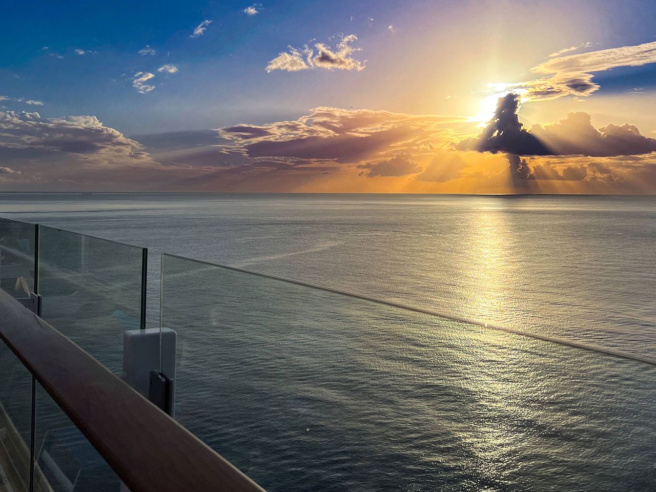 Blick vom Kreuzfahrtschiff über die Reling, untergehende Sonne