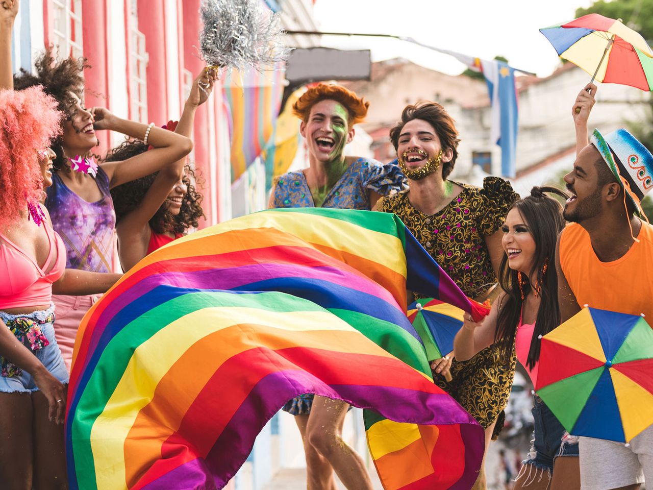 Freundesgruppe feiert Karneval in Olinda, geschmückt mit Regenbogenflagge